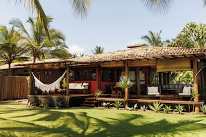 A wooden house with a tiled roof, a hammock, and a patio with chairs and tables. - #casa_oceano_barra_grande Luxury Villa (MARAU)
