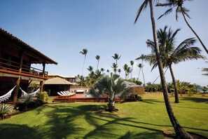 A resort with a pool, lounge chairs, and palm trees.