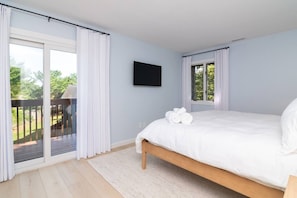 A bedroom with a bed, a TV, and a view of a deck. - Family Retreat Near Beach | 2 Decks, Access To Pool & Tennis (Rehoboth Beach)