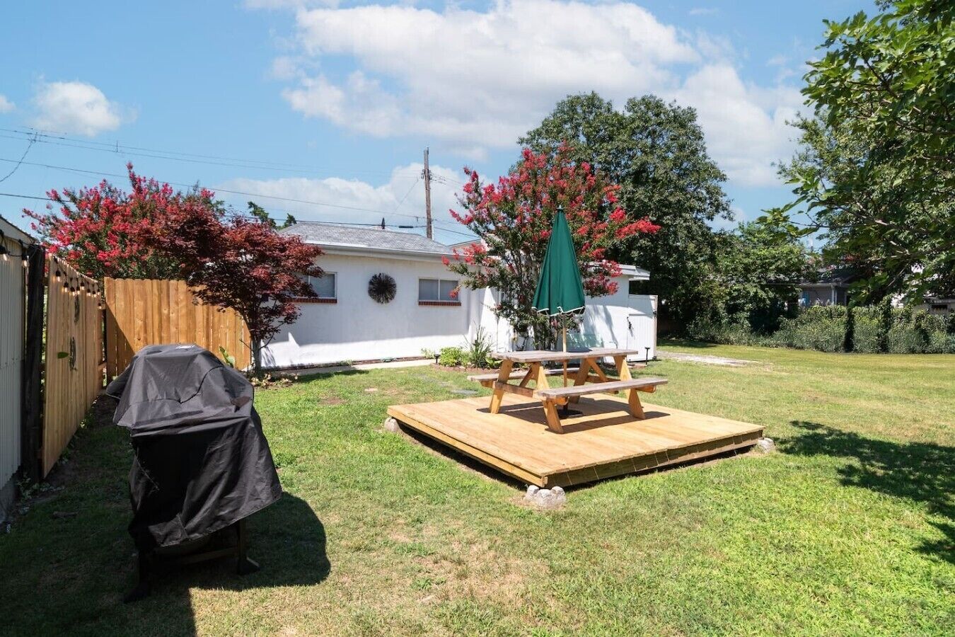 Spacious yard with outdoor dining and a propane grill.