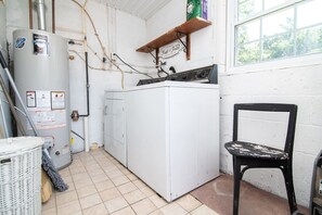 A laundry room with a washing machine, a heater, and a chair. - Beach Block 3BR Home - Walk to Beach, Dining & Bars (Dewey Beach)