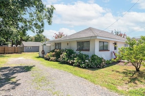 A single-story house with a front yard, a gravel driveway, and a wooden fence. - Beach Block 3BR Home - Walk to Beach, Dining & Bars (Dewey Beach)