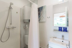 A bathroom with a shower, toilet, sink, and a window with a view. - Suoerb Apartment With Garden Heart of Deauville (Deauville)