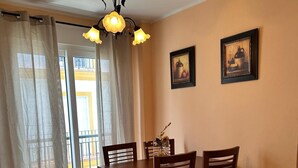 A dining area with a table and chairs, a chandelier, and two framed pictures on the wall. - Los Niños Apartment (Conil de la Frontera)