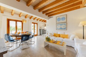 A spacious living area with a dining table, chairs, a sofa, and a coffee table. - The <b>Villa Son Fornes</b> has 3 bedroom(s) and capacity for 6 people. (Buger)