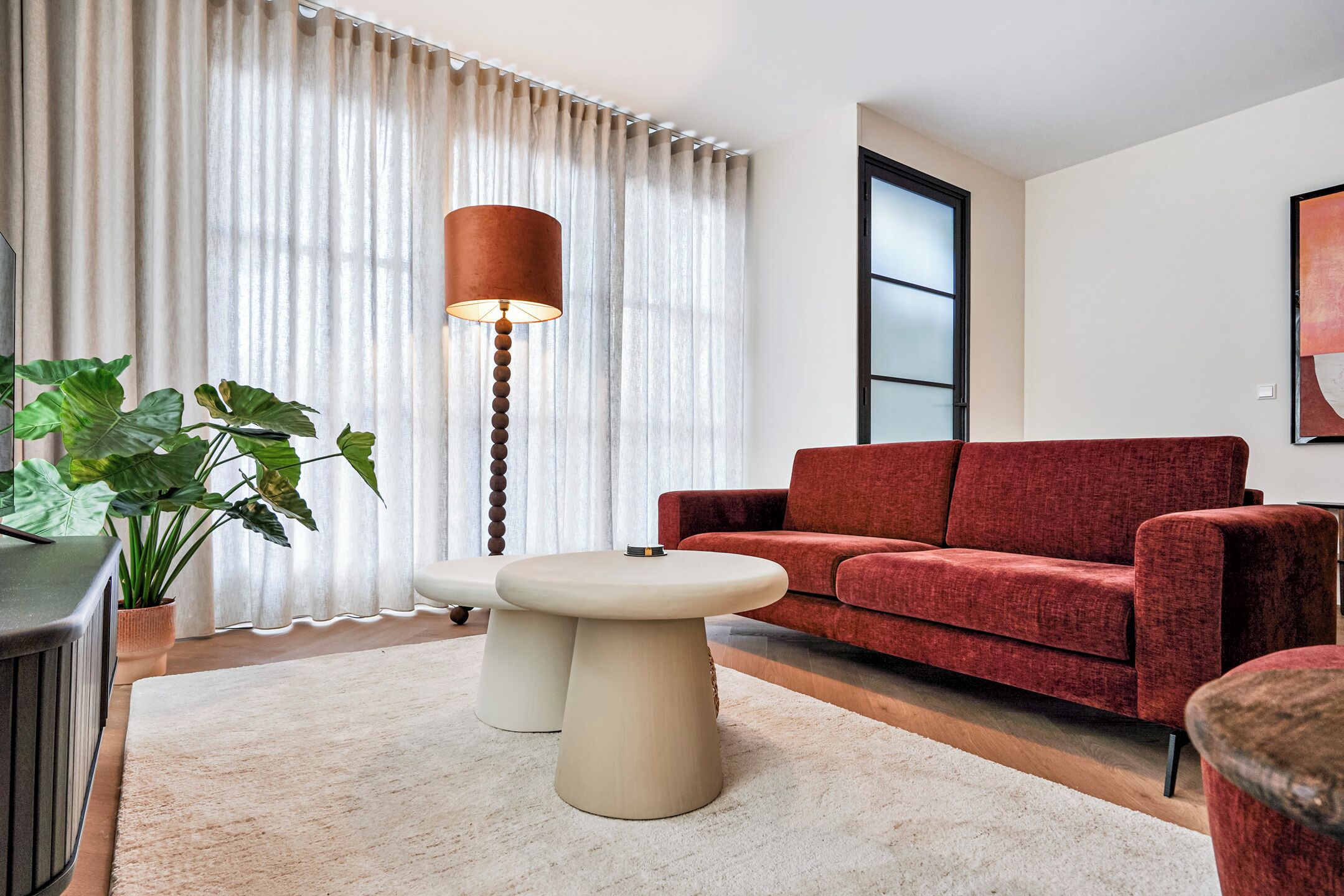 Bright and inviting living room with comfortable seating, large windows, Smart TV, and high-speed WiFi for a relaxing stay in Velden, Limburg.