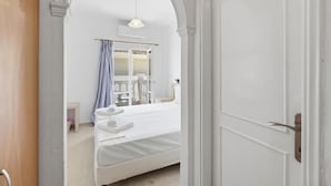 A bedroom with a bed, a hanging light, and a wardrobe. - Bed and Breakfast 'The Kavos Sandy Inn-Double Room' with Shared Pool, Wi-Fi and Air Conditioning (Kavos)