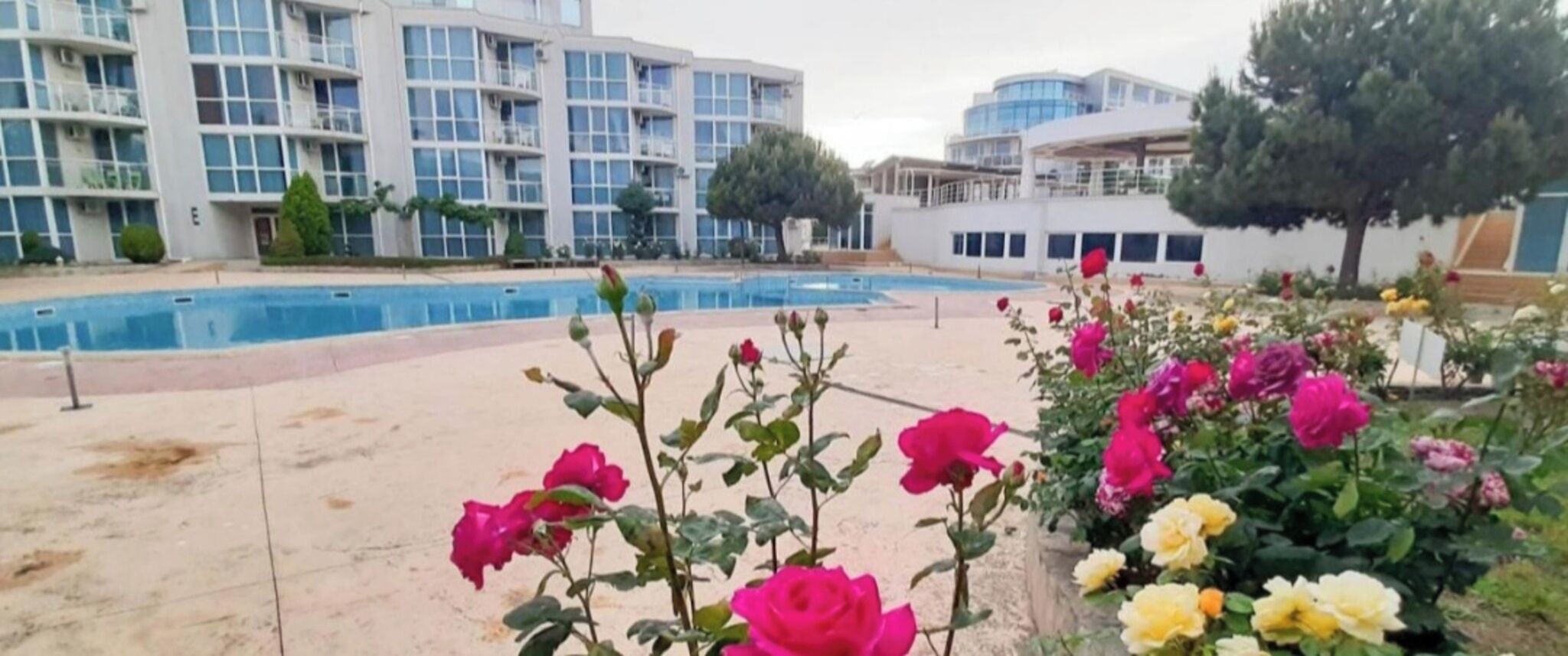 A swimming pool with a modern building in the background.