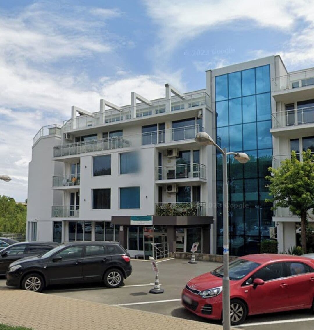 A multi-story building with a modern design, featuring balconies and large windows.