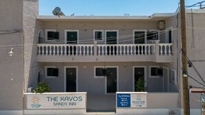 A two-story building with a sign for 'The Kavos Sandy Inn' and a 'Swimming Pool' sign. - Bed and Breakfast 'The Kavos Sandy Inn-Double Room' with Shared Pool, Wi-Fi and Air Conditioning (Kavos)