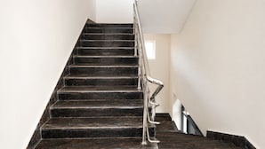 A staircase with a metal handrail and dark steps.