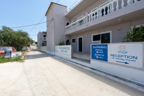 A building with a reception sign, a swimming pool, and a beach sign. - Bed and Breakfast 'The Kavos Sandy Inn-Double Room' with Shared Pool, Wi-Fi and Air Conditioning (Kavos)