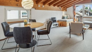 A modern interior with a dining area, seating, and a view of the outside. - A301 Appartement/Fewo,   Ferienwohnung A301 IH by Interhome (Lenzerheide)