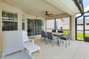 A covered patio area with a table and chairs, a ceiling fan, and a view of the outside. - Near Disney & Top Attractions! Poolside Oasis (Davenport)