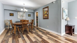 A dining room with a wooden table and chairs, a chandelier, and artwork on the walls. - 9 Mi to Dtwn Charleston! Park Circle Extended Stay (North Charleston)