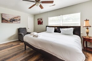 A bedroom with a large bed, a ceiling fan, a chair, a window with blinds, and artwork on the walls. - 9 Mi to Dtwn Charleston! Park Circle Extended Stay (North Charleston)