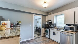 A modern kitchen with stainless steel appliances, a herringbone wood floor, and a view to the dining area. - 9 Mi to Dtwn Charleston! Park Circle Extended Stay (North Charleston)