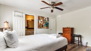 A bedroom with a bed, a dresser, a nightstand, a lamp, a ceiling fan, and a door leading to a bathroom. - 9 Mi to Dtwn Charleston! Park Circle Extended Stay (North Charleston)