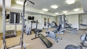 A gym with various exercise equipment, including treadmills, stationary bikes, and weight machines. - Pool Access & Balcony! Colorado Springs Getaway (Colorado Springs)