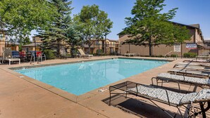 A swimming pool with lounge chairs and a fenced area. - Pool Access & Balcony! Colorado Springs Getaway (Colorado Springs)