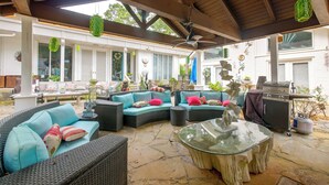 An outdoor patio area with wicker furniture, a glass table, and a barbecue grill. - Pool, Putting Green Access! Backyard Retreat (Thomaston)