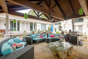 An outdoor patio area with wicker furniture, a glass table, and a barbecue grill. - Pool, Putting Green Access! Backyard Retreat (Thomaston)