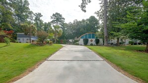 A residential driveway leading to a house with a well-maintained lawn and mature trees. - Pool, Putting Green Access! Backyard Retreat (Thomaston)