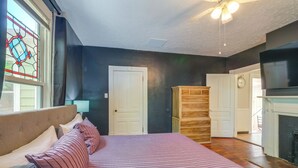 A bedroom with a bed, a dresser, a clock, and a fireplace. - 2 Lynchburg Units: Mansfield Manor & King's Suite! (Lynchburg)