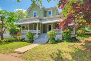 A two-story house with a front porch, a covered entryway, and a small front yard.