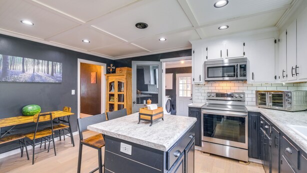 A modern kitchen with white cabinets, stainless steel appliances, and a marble countertop. - 2 Lynchburg Units: Mansfield Manor & King's Suite! (Lynchburg)