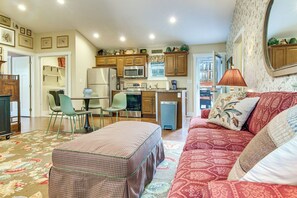 A compact living space with a kitchenette, a dining area, and a seating area with a sofa and ottoman. - Walk to Waynesville Hot Spots! 'woodland Cottage' (Waynesville)