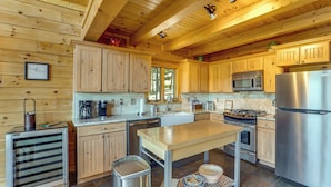 A modern kitchen with wooden cabinetry, stainless steel appliances, and a central island.