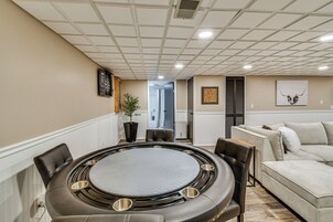 Una sala de conferencias con una mesa redonda, sillas, una planta en maceta y un sofá al fondo.