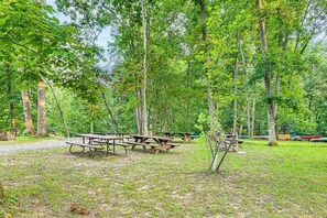 Un terrain de camping équipé de tables de pique-nique et de canoës.