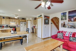 Uma cozinha espaçosa com armários de madeira, uma mesa de jantar e um sofá vermelho na sala de estar.
