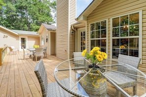 A glass-top round table with wicker chairs and a vase of sunflowers on a wooden deck. - Near Lake Allatoona! Suburban Home w/ Deck & Yard (Dallas)