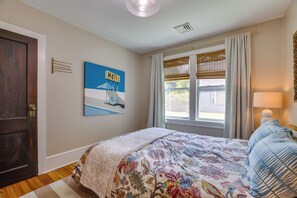 A bedroom with a bed, a window with curtains, a wall-mounted sign, and a door. - Family-friendly Poconos Getaway 11 Mi to Kalahari! (Mountainhome)