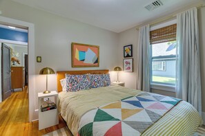 A bedroom with a bed, two bedside lamps, a nightstand, a window with curtains, and a wall with a framed picture. - Family-friendly Poconos Getaway 11 Mi to Kalahari! (Mountainhome)