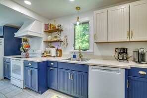 A modern kitchen with blue cabinets, a built-in oven, a dishwasher, and a coffee maker. - Family-friendly Poconos Getaway 11 Mi to Kalahari! (Mountainhome)
