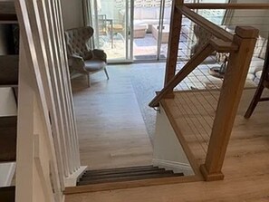 Eine Holztreppe führt zu einem Raum mit Blick ins Freie.