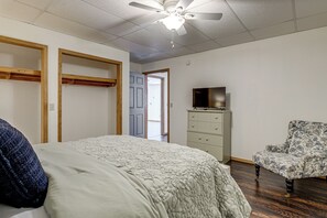 A bedroom with a bed, a dresser, a chair, a ceiling fan, and a door leading to another room. - 8-acre Family Reunion Retreat! 8 Mi to Bentonville (Pea Ridge)