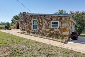 A stone house with two windows and a front porch. - Texas Hill Country Home: Quiet Yard + Patio (Richland Springs)