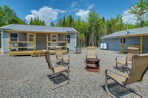 A cabin with a gravel patio, outdoor seating, and a fire pit.