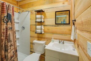 A bathroom with a shower, toilet, and sink.