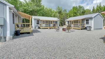 A campground with two cabins, each with a porch and seating area.