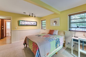 A bedroom with a bed, a desk, a radiator, and a window with blinds. - Boating, Bonfires & Lake Views! Michigan Getaway (Ellsworth)