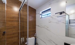 A modern bathroom with a glass shower enclosure, a marble wall, and a small window. - Apt. w/ City View, Centro Cabo Frio Piu0105 (Cabo Frio)