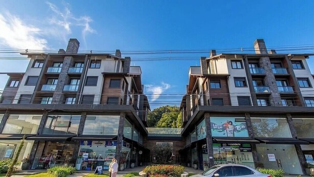 A modern building with multiple floors, large windows, and a central atrium. - Apt. w/ Fireplace & Balcony in Gramado Ohs0501 (Gramado)