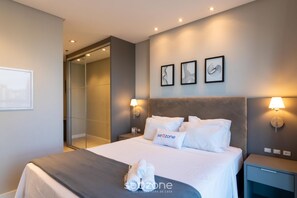 A modern hotel room with a bed, two wall-mounted lamps, a nightstand, and a mirror. - Apt. in Condo. w/ Pool & Sea View Mhf1305 (Itapema)