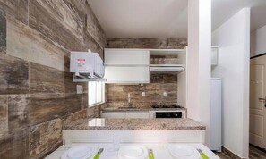 Eine moderne Küche mit Granit Arbeitsplatte, weißen Schränken und einer eingebauten Mikrowelle.